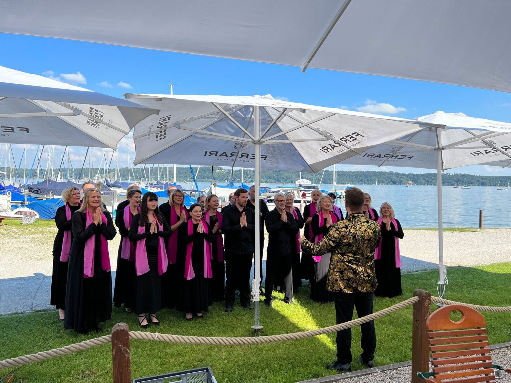 Gospels at Heaven singt bei einer privaten Feier; Im Hintergrund ist der Starnberger See zu sehen